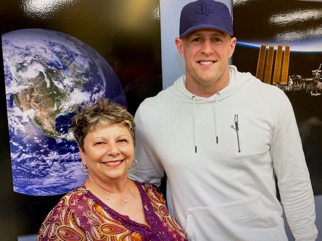 A secretary at Johnson Space Center poses for a picture with former NFL Houston Texans player J.J. Watt.