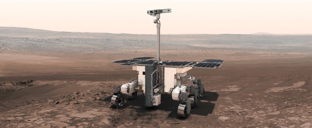 An artist's concept of the ExoMars Rosalind Franklin rover on the surface of Mars. The ground is brown and dusty, and the sky is hazy and tan.