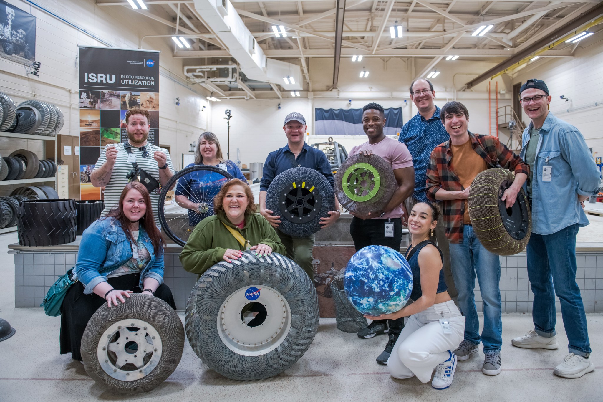 en smiling people hold different types of tires.