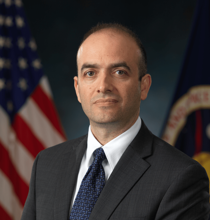 Headshot of Omar Hatamleh in front of American and NASA flags.