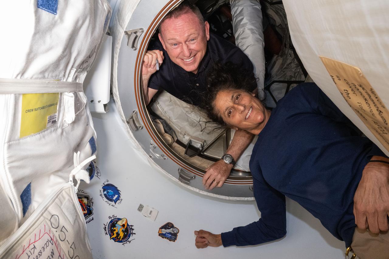 NASA's Boeing Crew Flight Test astronauts (from top) Butch Wilmore and Suni Williams pose on June 13, 2024 for a portrait inside the vestibule between the forward port on the International Space Station's Harmony module and Boeing's Starliner spacecraft.