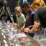 A teacher interning at Johnson Space Center helps youth guests with an activity during Bring Youth to Work Day 2024.