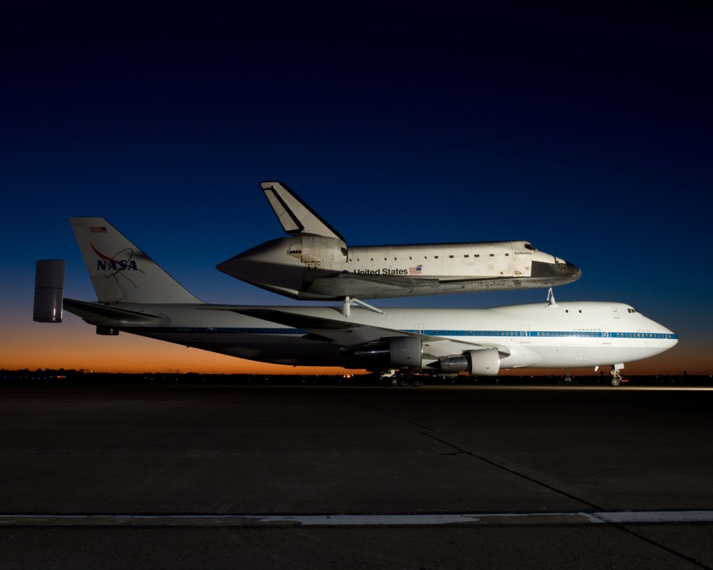 A NASA space shuttle mounted on top of the Shuttle Carrier Aircraft.