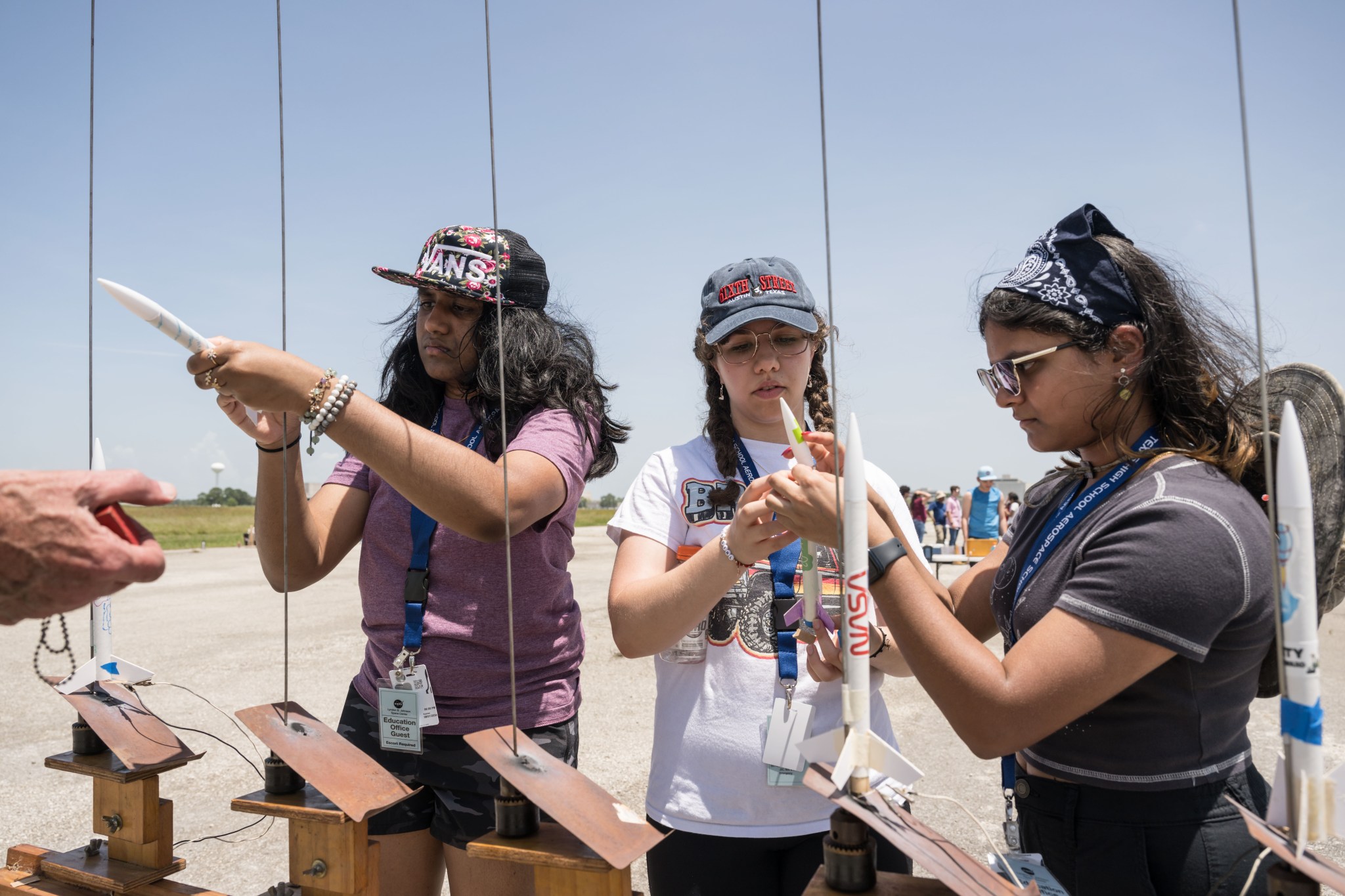 High school students prepare model rockets for launch.