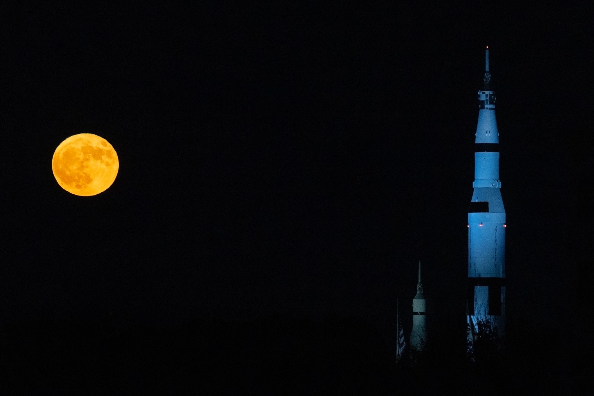 A super blue moon is to the left of the replica Saturn V at the US Space and Rocket Center in Huntsville, Alabama.