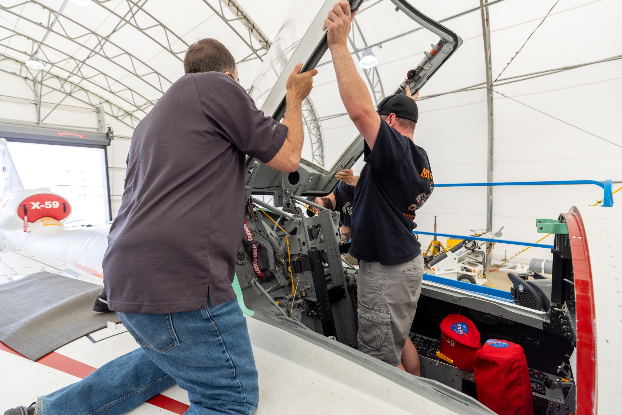 Three men removing the X-59 canopy.