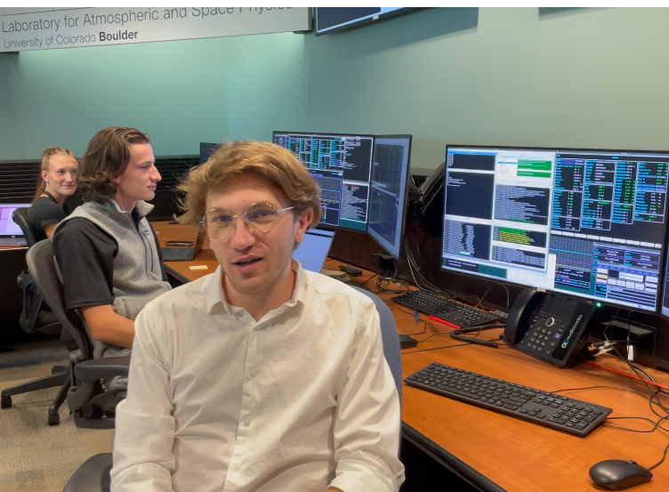 Sam Lippincott, right, a graduate student lead at LASP, trained as a command controller for NASA's IXPE spacecraft as an undergraduate. In the background are flight controllers Adrienne Pickerill, left, and Alexander Pichler, who also trained as students.