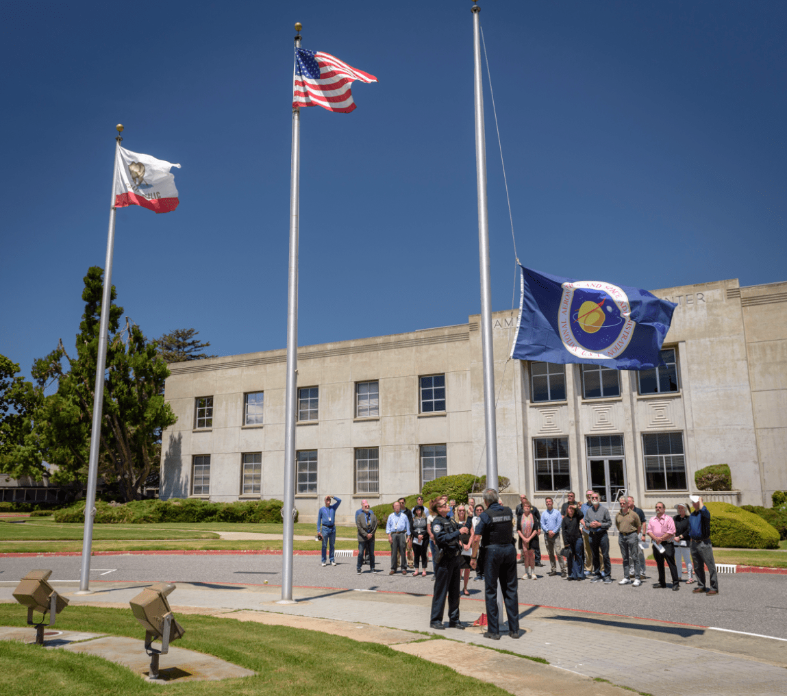 NASA Protective Services lower the NASA flag to honor the life of Alan Rhodes in front of the Ames Administration building, N200 on July 31.