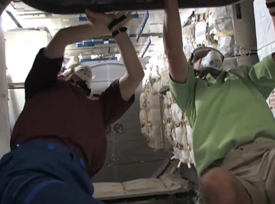 Frank DeWinne, left, and A. Christer Fuglesang, both of the European Space Agency, open the hatch to the Leonardo Multi-Purpose Logistics Module