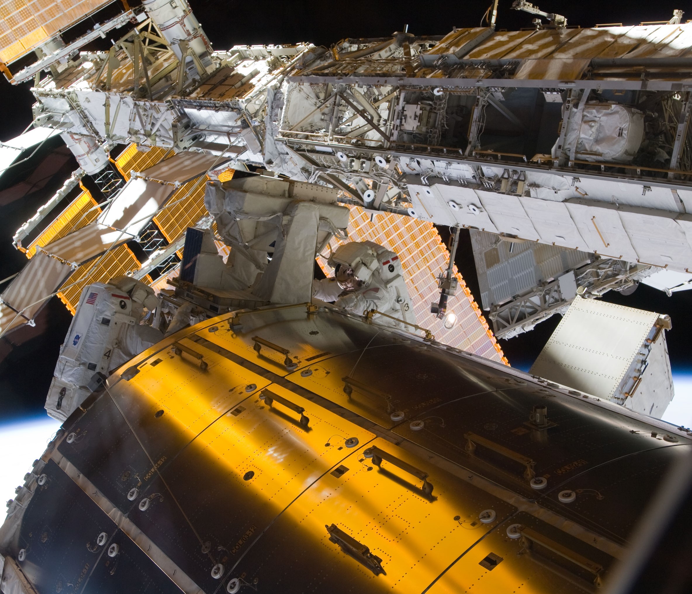 John D. “Danny” Olivas, left, and Nicole P. Stott remove the EuTEF experiment from the Columbus module