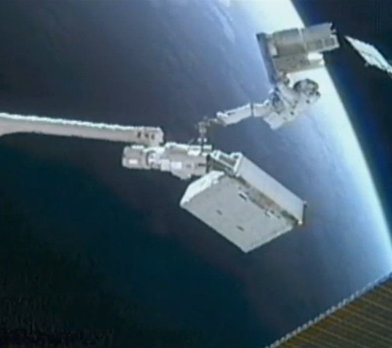 Stott rides the station robotic arm carrying the EuTEF experiment, with the removed Ammonia Tank Assembly attached to it