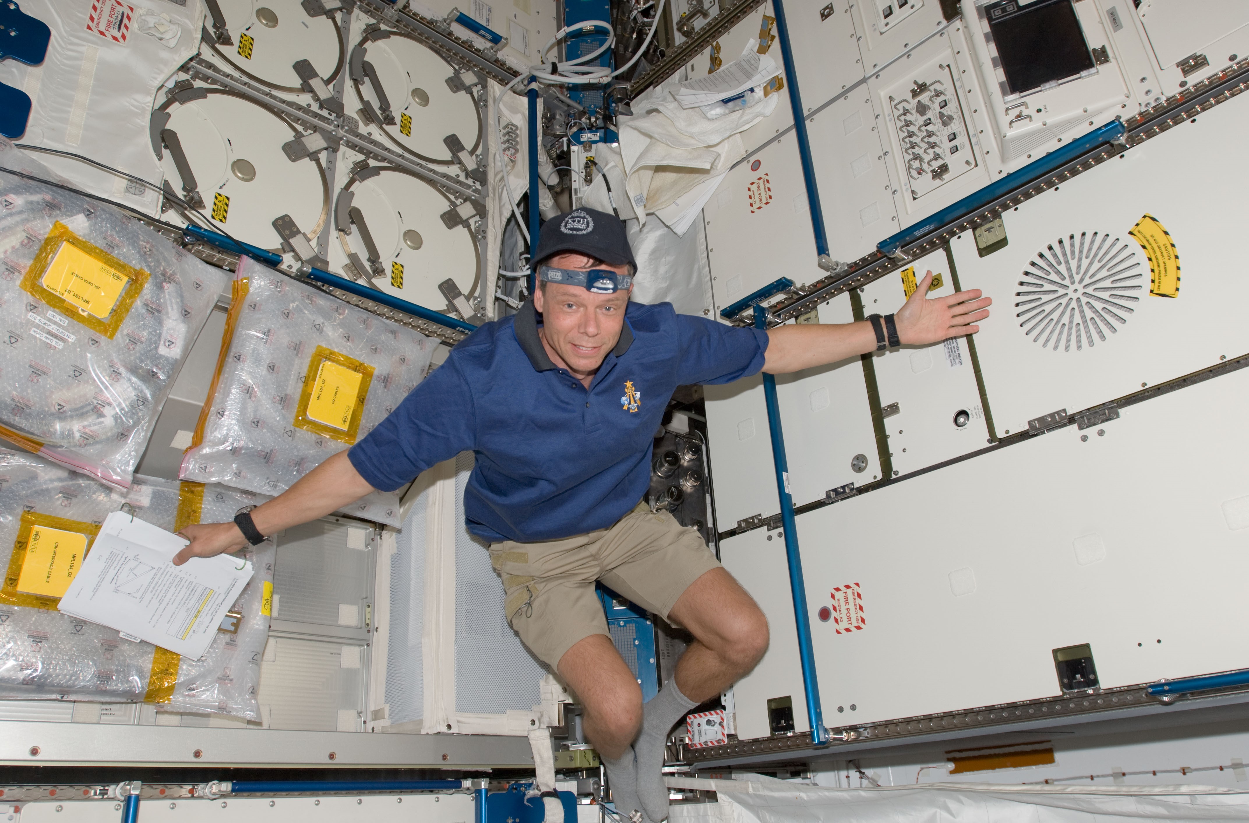 A. Christer Fugelsang of the European Space Agency shows off his installation of the Air Revitalization System rack in the Kibo module