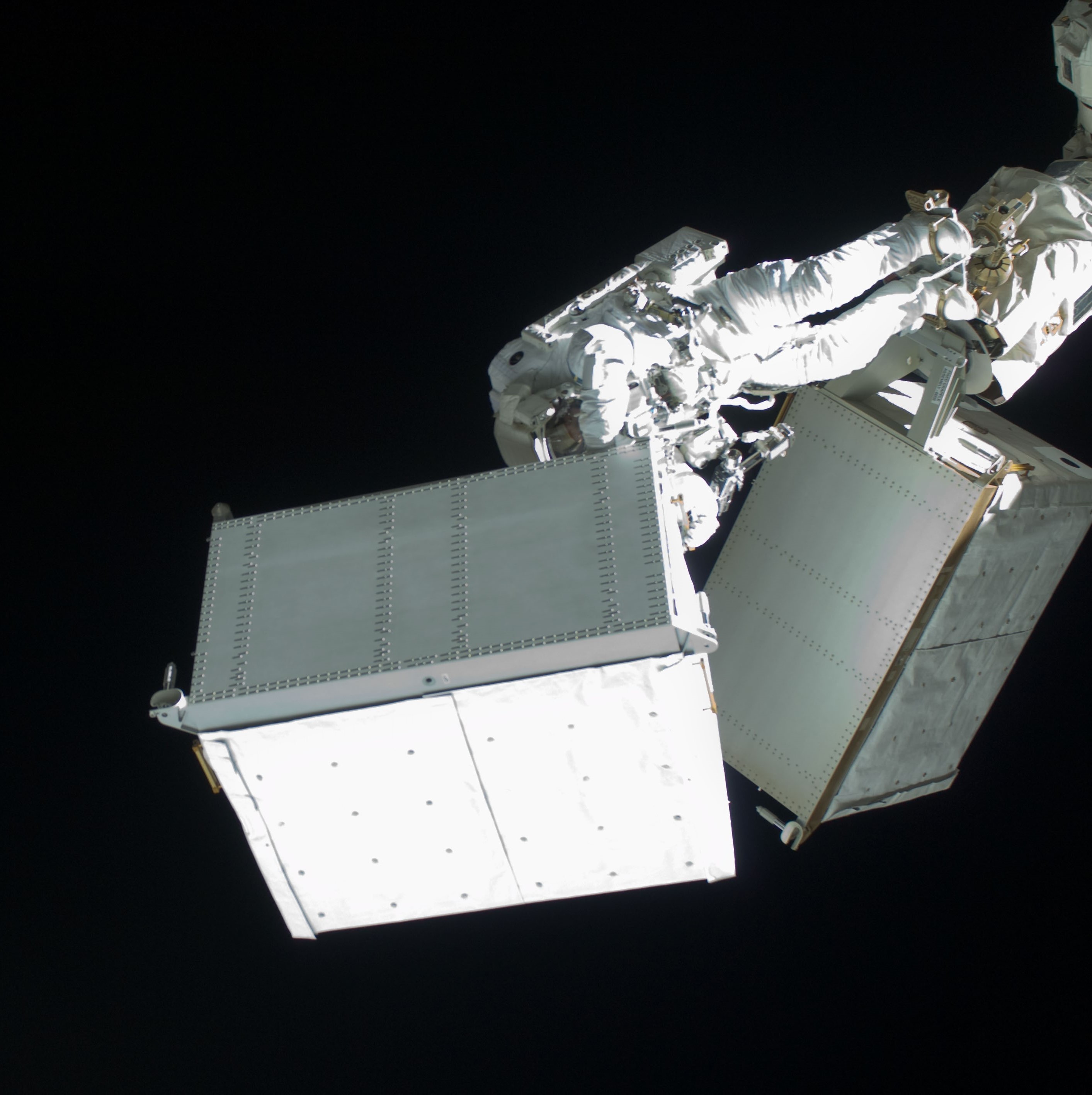 A. Christer Fuglesang carries both the old and the new Ammonia Tank Assemblies (ATA) on the end of the space station robotic arm