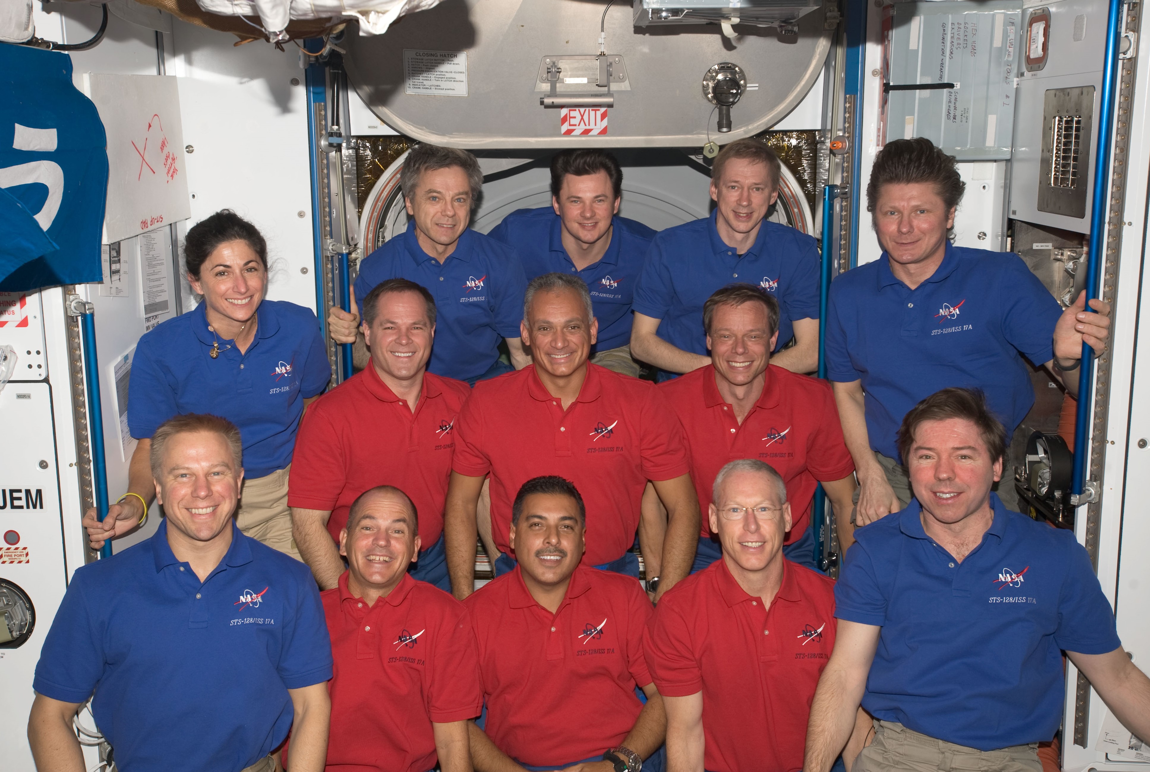 The 13 members of Expedition 20, blue shirts, and STS-128, red shirts, pose for a final photograph before saying their farewells