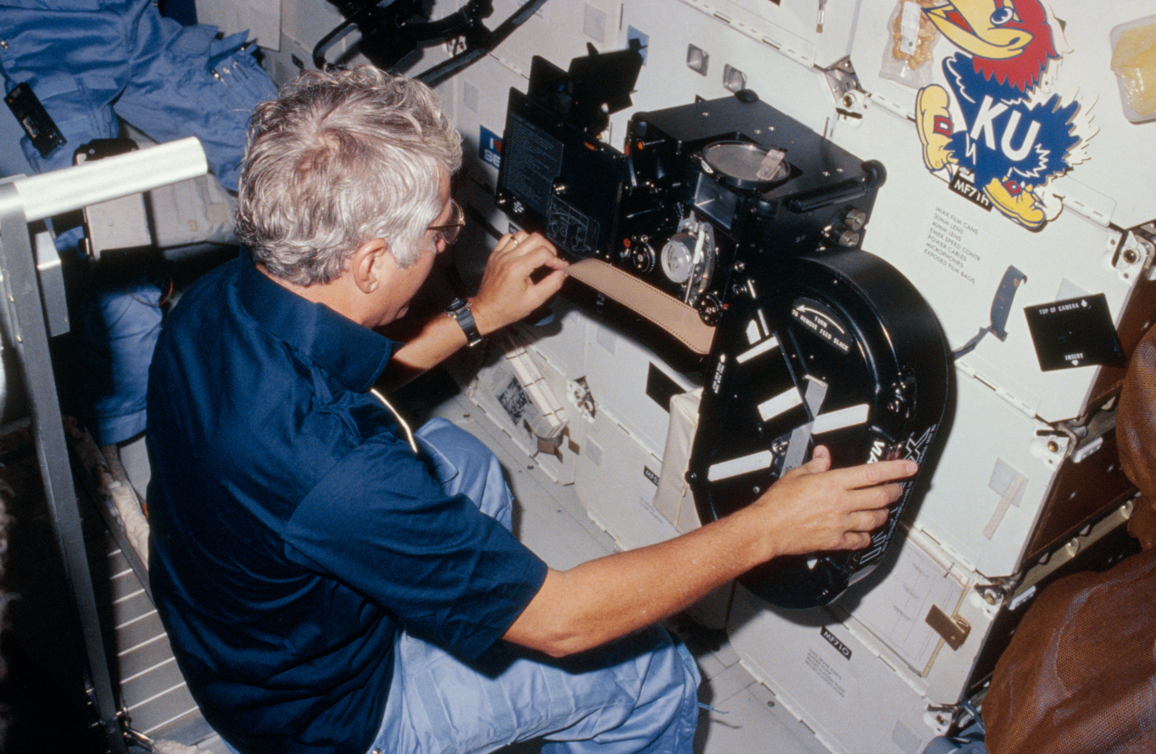 Henry “Hank” W. Hartsfield loading film into the IMAX® camera