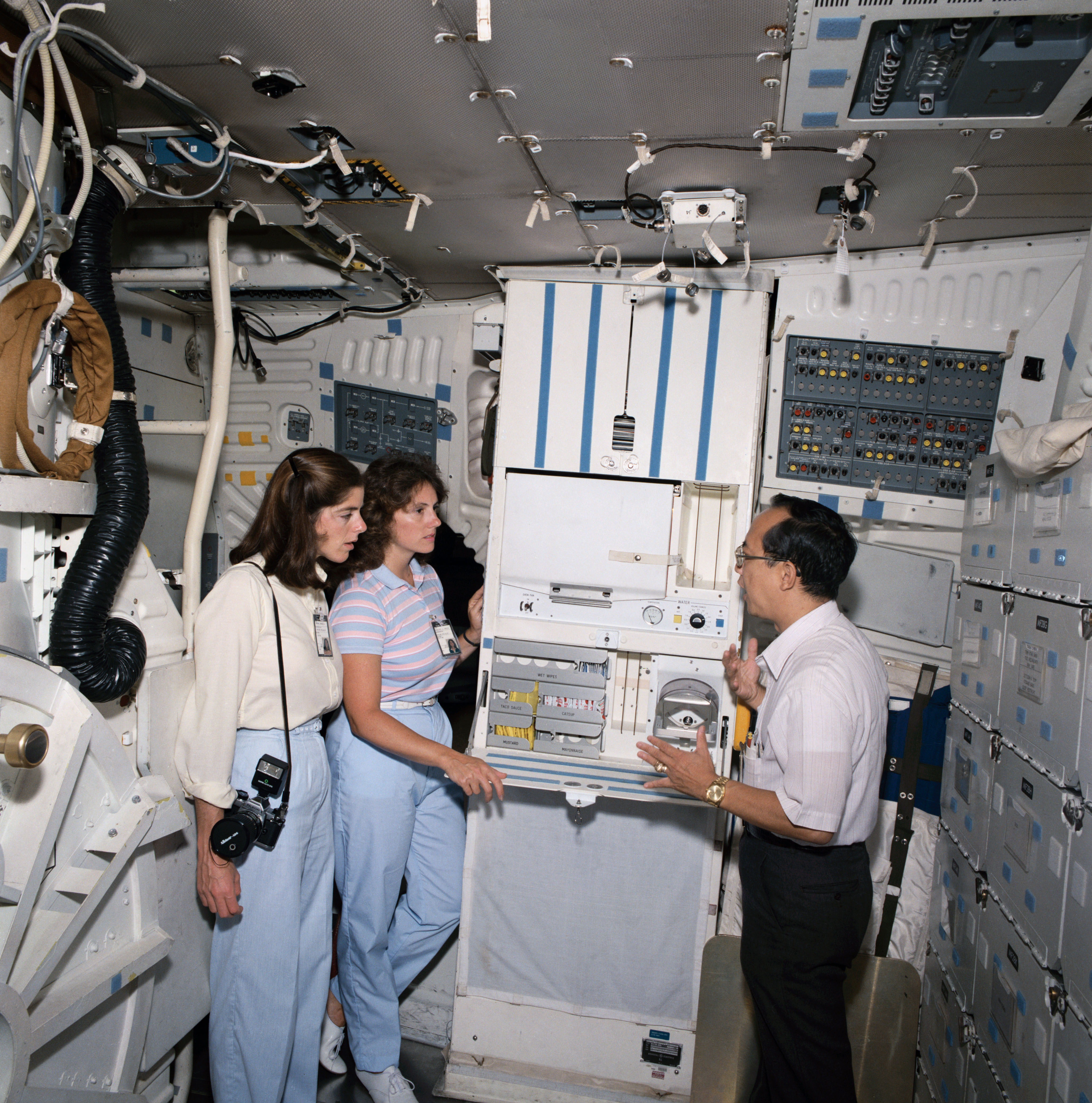 Morgan, left, and McAuliffe receive a briefing on the space shuttle galley