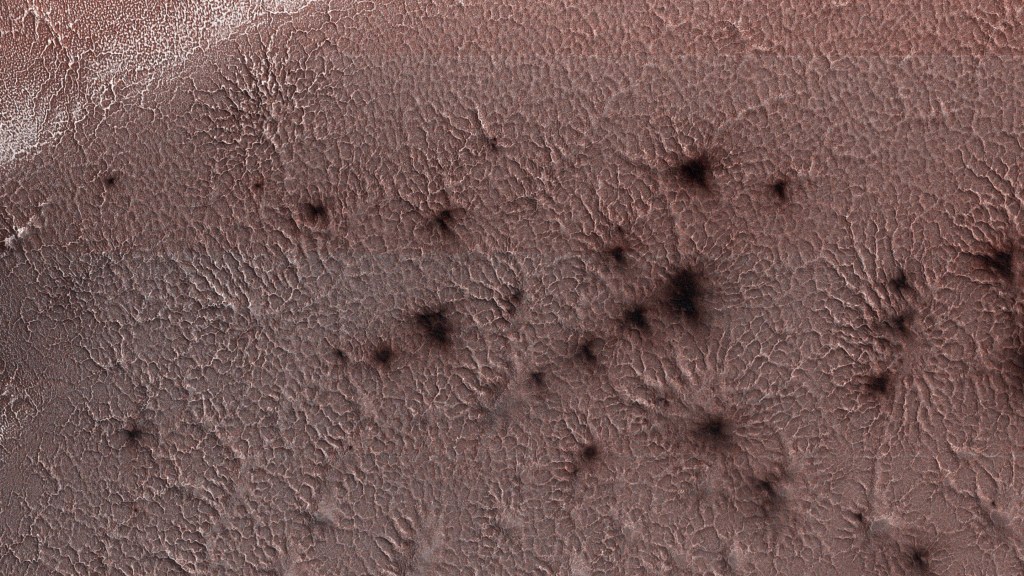 Dark splotches seen in this example of araneiform terrain captured by NASA's Mars Reconnaissance Orbiter in 2018