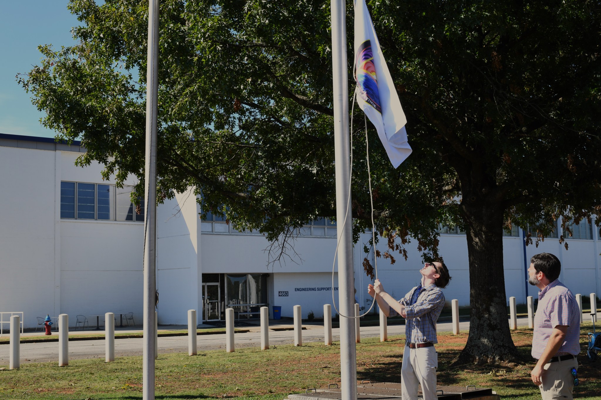 Thomas "Reid" Lawrence raises the Crew-9 mission flag as Doepke looks on during the flag-raising ceremony to honor NASA’s Space X Crew-9 Mission to the International Space Station.