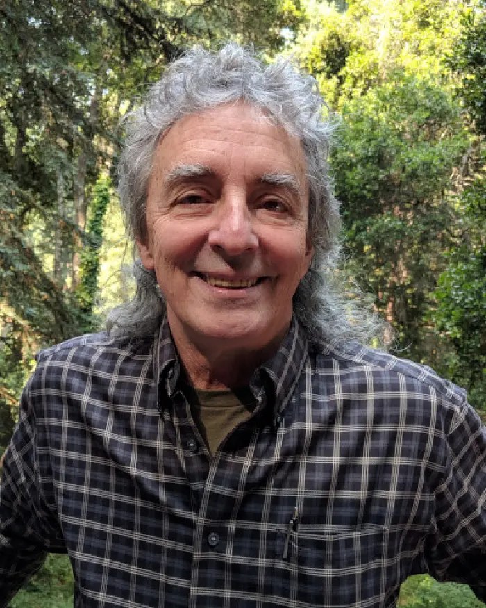 A scientist named Don Sullivan from NASA Ames Research Center standing in a forest for a portrait photo.