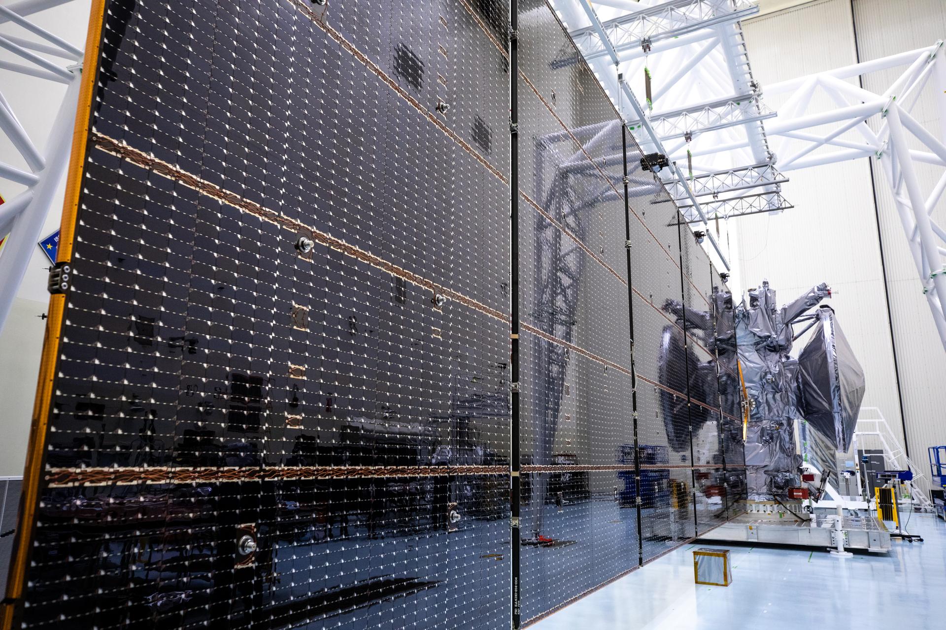 A close up image of a set of massive solar arrays measuring about 46.5 feet (14.2 meters) long and about 13.5 feet (4.1 meters) high on NASA’s Europa Clipper spacecraft inside the agency’s Payload Hazardous Servicing Facility at Kennedy Space Center in Florida.