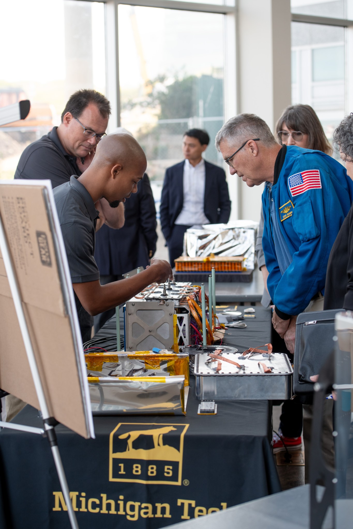 NASA astronaut Stephen Bowen, who flew on three space shuttle missions and served as commander of the SpaceX Crew-6 mission in 2023, engages with one of the Phase 2 finalist teams about their innovative hardware at NASA’s Watts on the Moon Challenge Technology Showcase and Winners’ Event at the Great Lakes Science Center in Cleveland, Ohio, on Sept. 20. Prototypes like the one shown here aim to provide power transmission and energy storage capabilities to the lunar south pole.