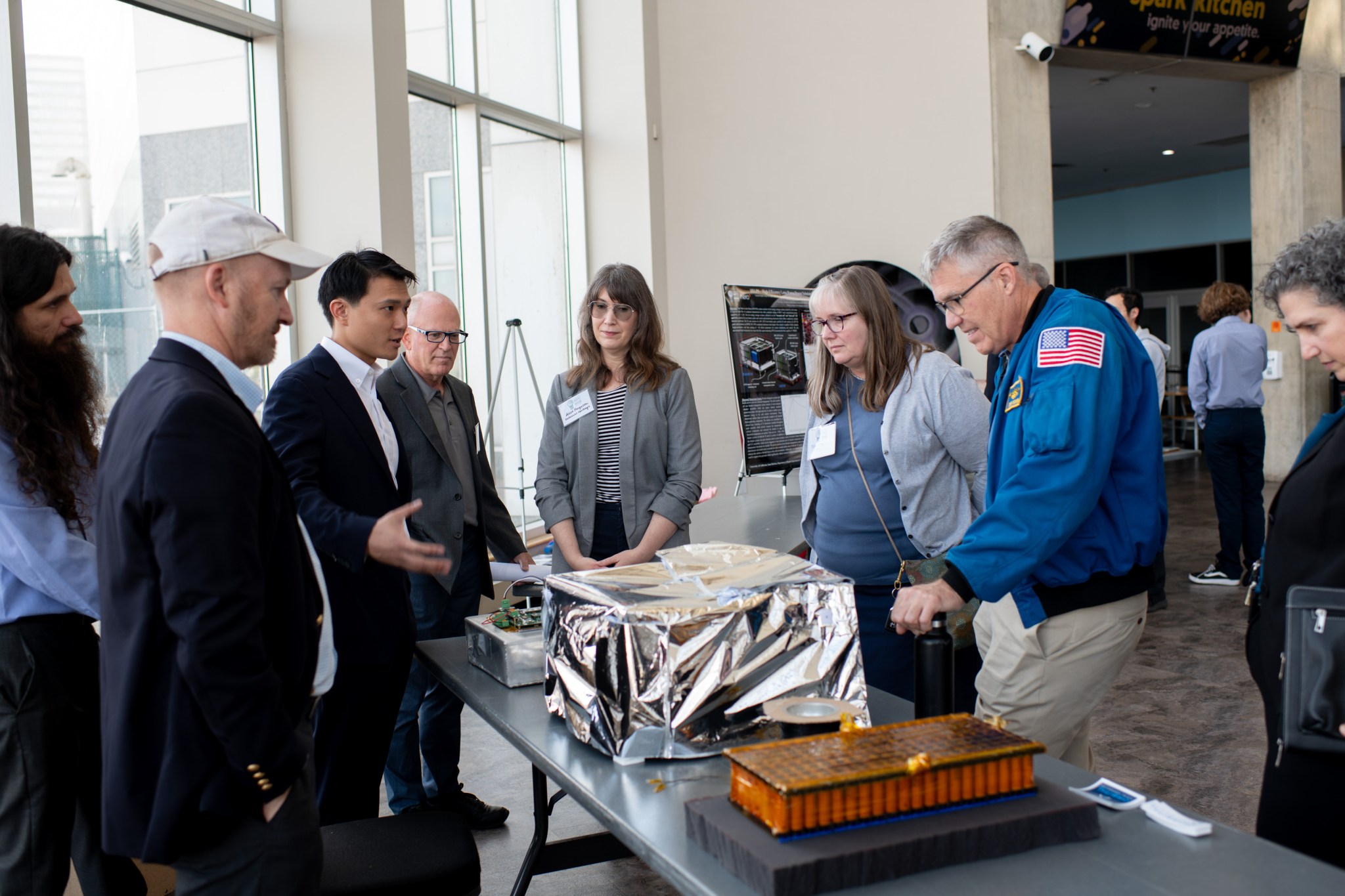 Mary Wadel, center right, NASA Glenn Research Center’s Director of Research, Technology, and Partnerships, Bowen, and Great Lakes Science Center President and CEO Kirsten Ellenbogen, right, listen intently while Orbital Mining Corporation team lead Ken Liang explains his team’s approach to the mission scenario behind the Watts on the Moon Challenge. His team’s power transmission and energy storage technology took home the second-place prize in the four-year, $5 million challenge, winning a cash prize of $500,000.