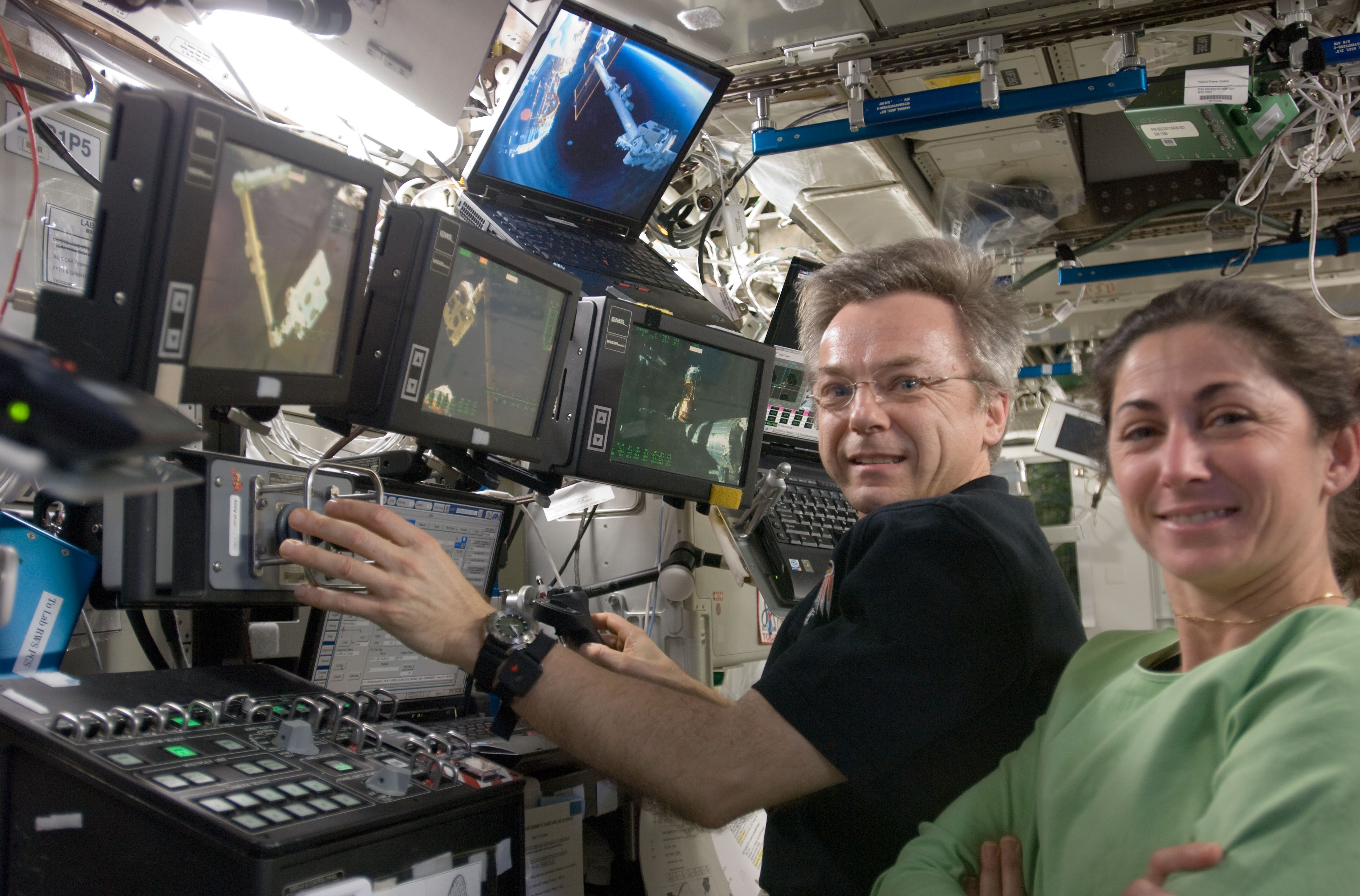 Canadian Space Agency astronaut Robert Thirsk and NASA astronaut Nicole P. Stott operate the station’s robotic arm to temporarily transfer the EP and its payloads to the JEM-EF