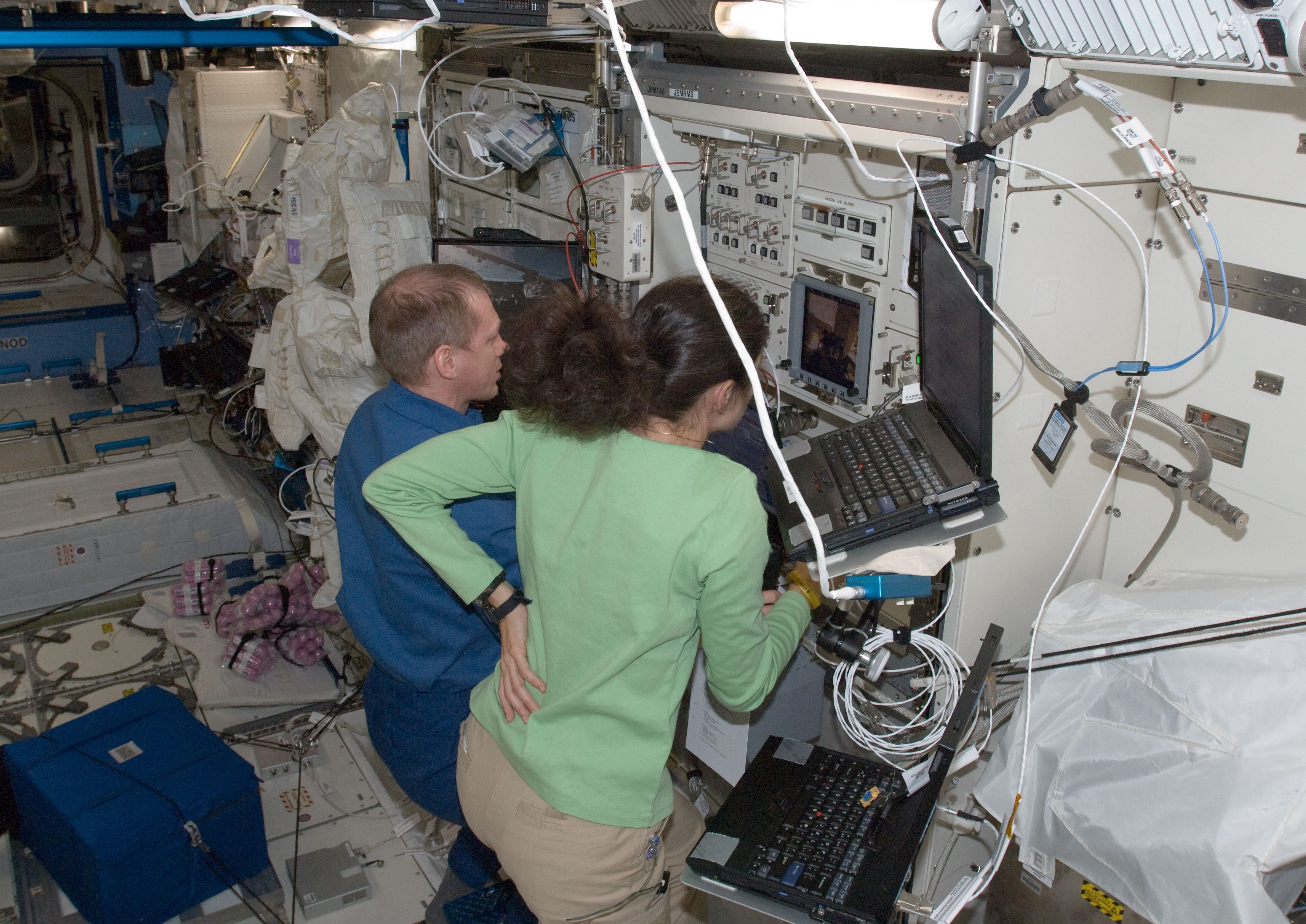 European Space Agency astronaut Frank DeWinne, left, and NASA astronaut Nicole P. Stott operate the Japanese robotic arm from inside the JEM