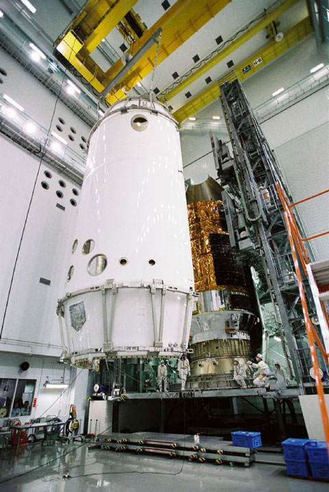 Technicians place HTV-1 inside its launch protective shroud at the Tanegashima Space Center