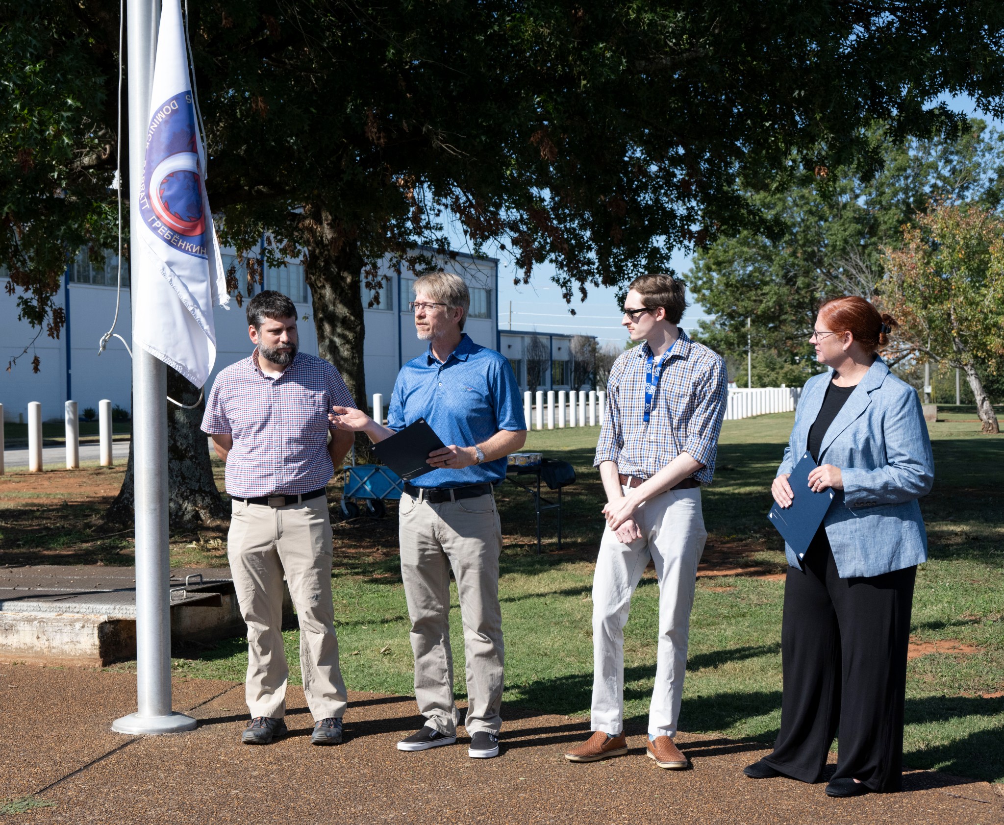 Dave Gwaltney, second from left, technical assistant, specialty system and Commercial Crew Program representative at NASA’s Marshall Space Flight Center, gives introductions during the Crew-9 flag-raising ceremony Sept. 19 outside the Huntsville Operations Support Center. He is joined by, from left, Brady Doepke, Thomas “Reid” Lawrence, and Nicole Pelfrey, manager of the Payload and Mission Operations Division.