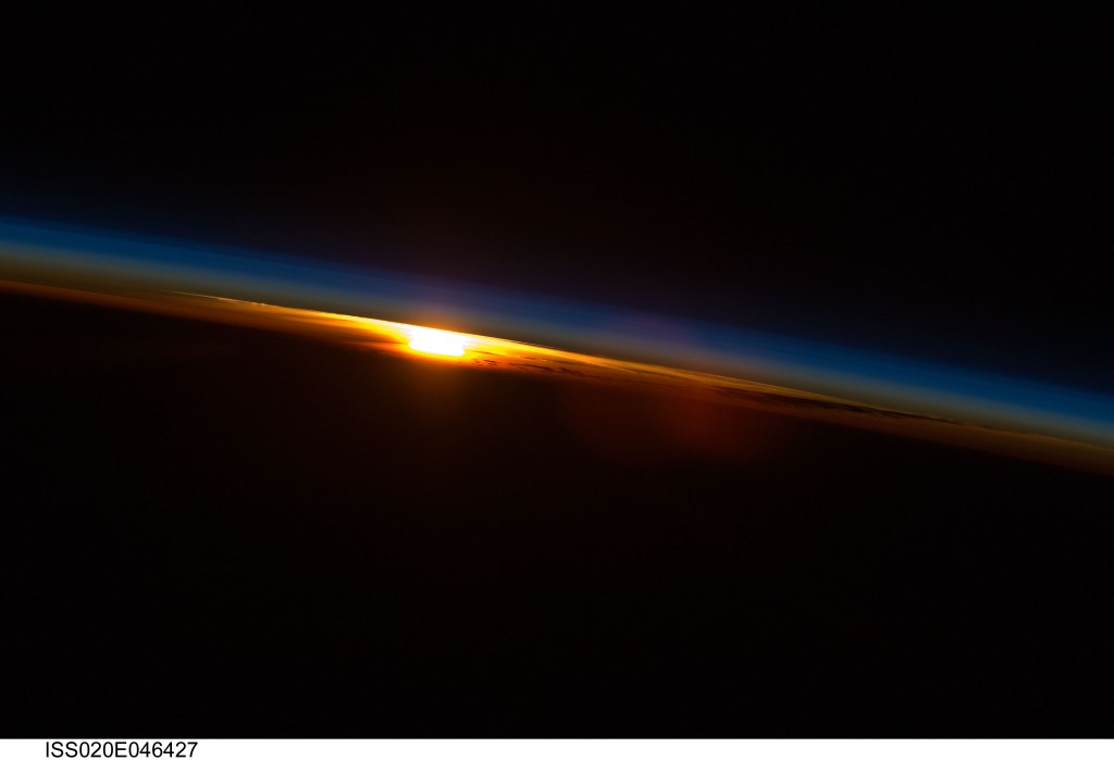 The sun sets below Earth's horizon illuminating the atmosphere with its last rays in this photograph from the International Space Station as it orbited 216 miles above near the Indian Ocean coast of South Africa.