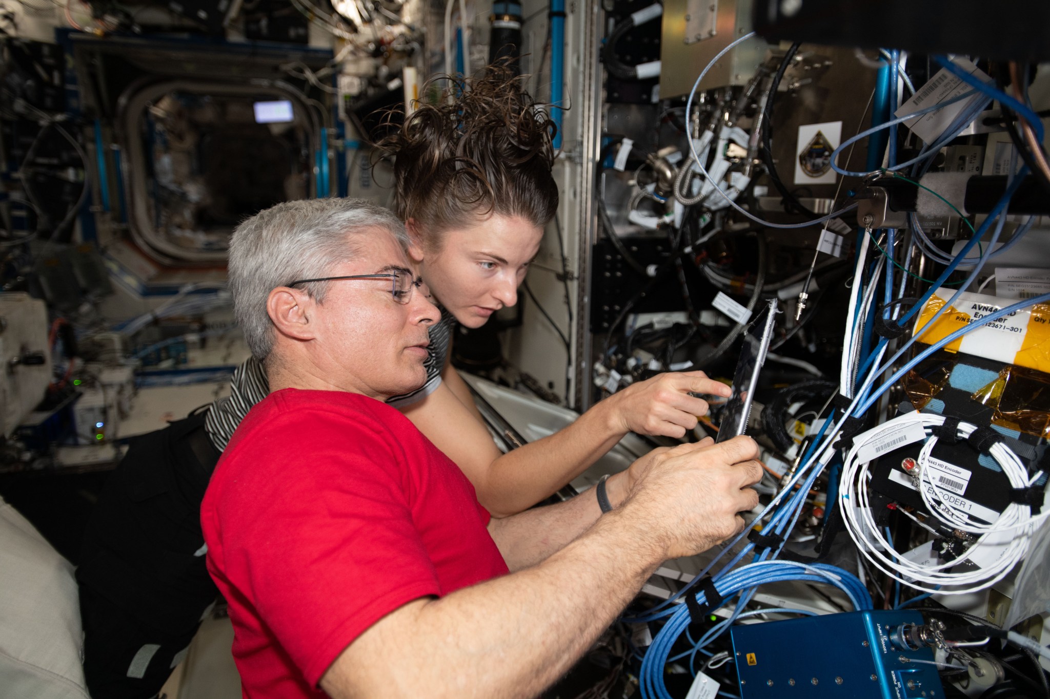 Two NASA astronauts prepare an experiment on the International Space Station.