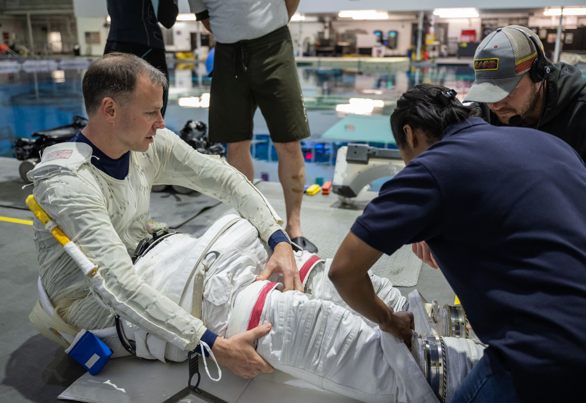 A NASA astronaut puts on a spacesuit as he prepares for spacewalk training in the Neutral Buoyancy Lab.