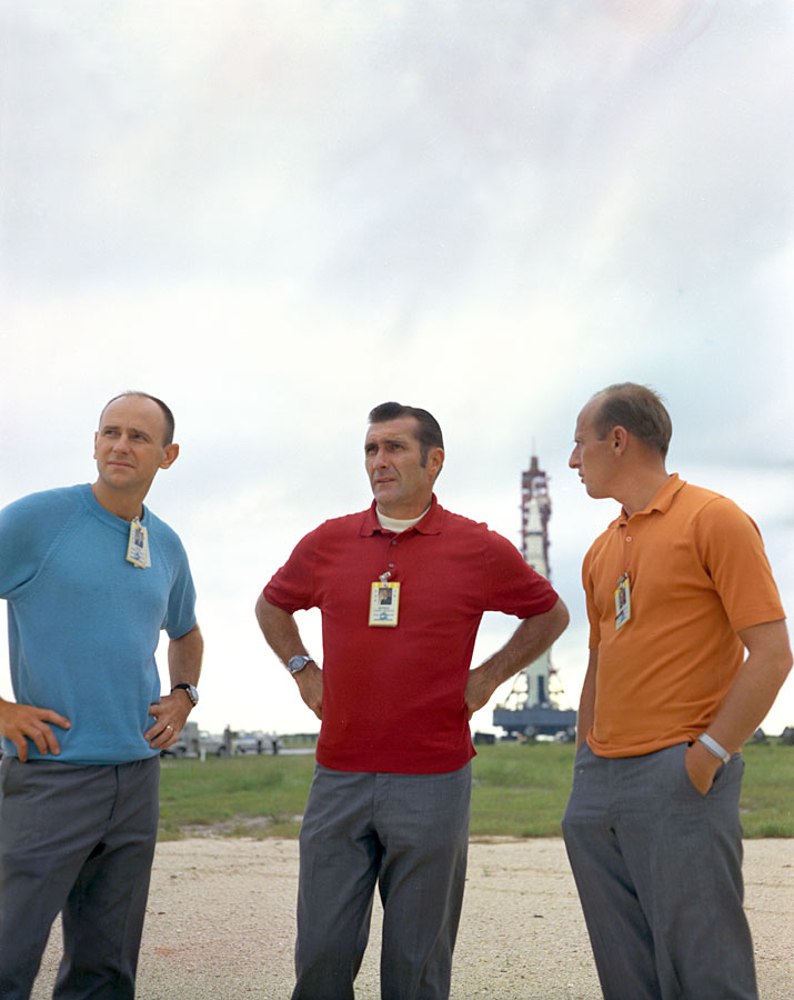 Apollo 12 astronauts Alan L. Bean, left, Richard F. Gordon, and Charles “Pete” Conrad pose in front of their Saturn V during the rollout to the pad