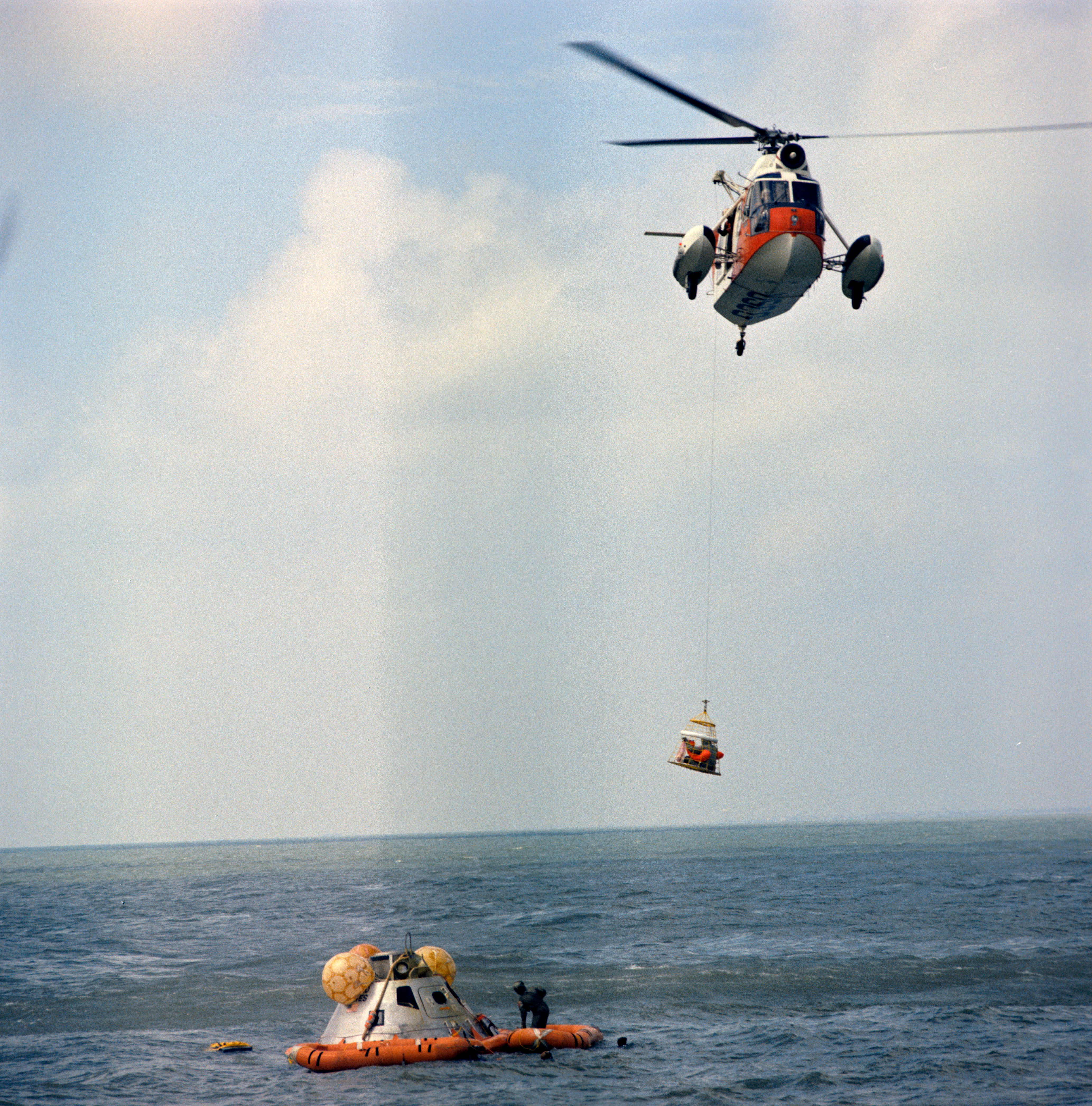 The recovery helicopter hoists the third crew member using a Billy Pugh net