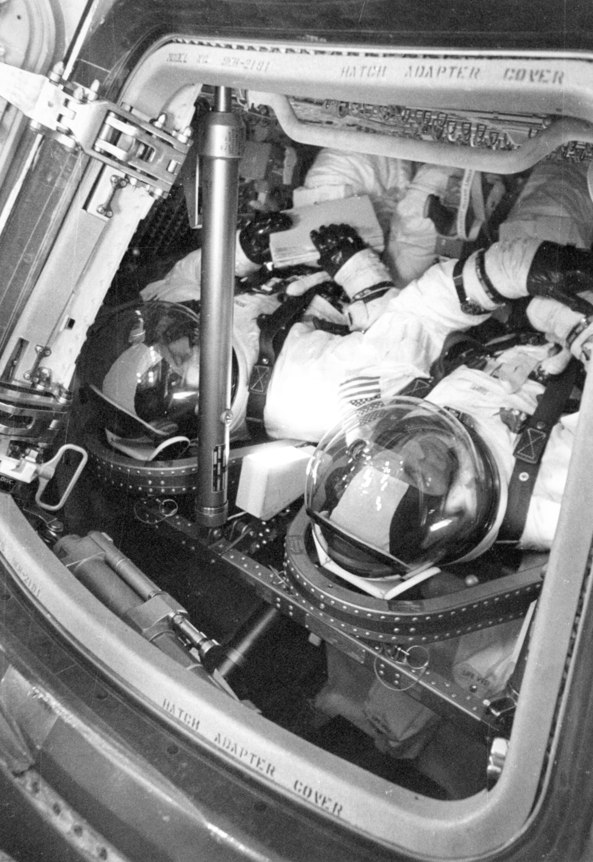 Apollo 13 backup crew members John W. Young, left, and Swigert in the CM for an altitude chamber test – Charles M. Duke is out of the picture at right