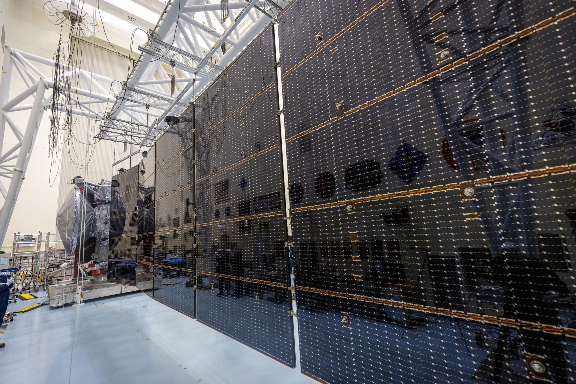 Large black rectangular solar arrays stretch out from the foreground to the back.