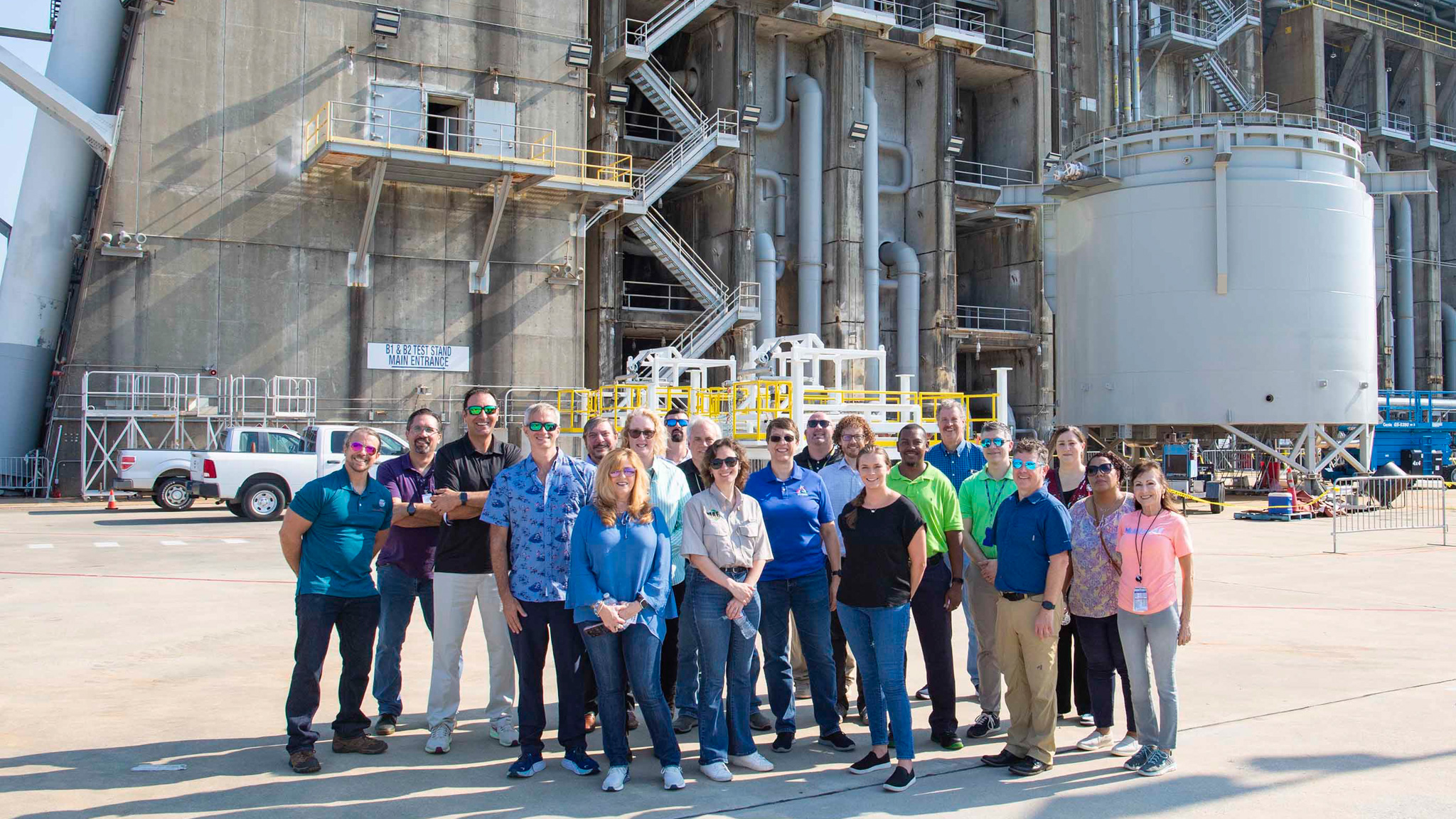 NASA’s Rocket Propulsion Test Program Office team members stand at the base of the Thad Cochran Test Stand during a tour of the test complex