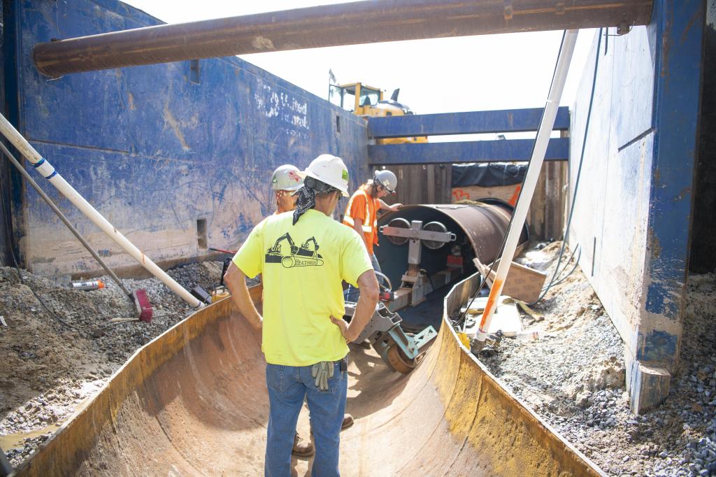 Crews use a specially designed tool to place a new pipeline liner inside the existing carrier pipe near the Fred Haise Test Stand.