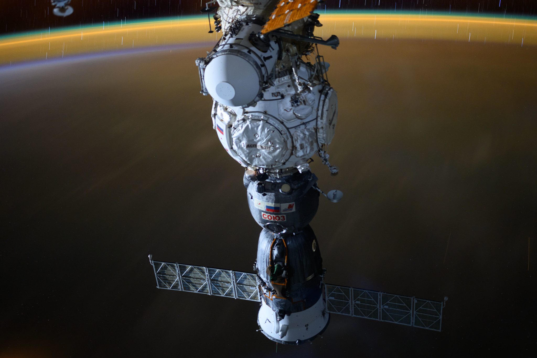 A long-duration photograph of a Roscosmos Soyuz spacecraft docked to the International Space Station’s Prichal module as the station orbits 258 miles above Nigeria.