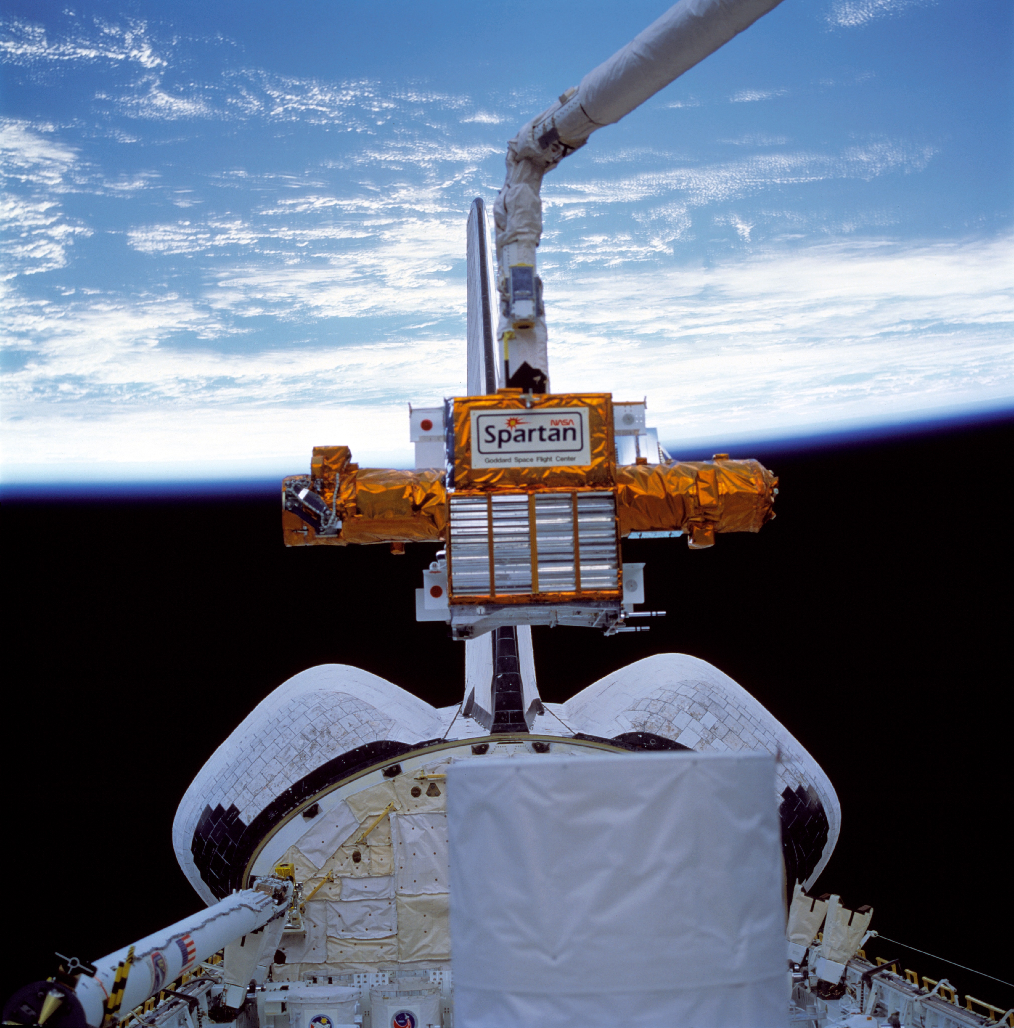 Astronaut Susan J. Helms lifts the Shuttle Pointed Autonomous Research Tool for Astronomy-201 (SPARTAN-201) out of Discovery's payload bay prior to its release