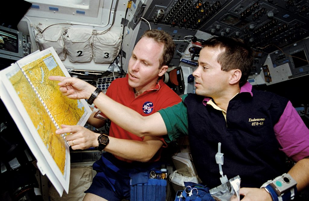 Thomas D. Jones, left, and Daniel W. Bursch consult a map in an atlas developed specifically for the SRL-2 mission