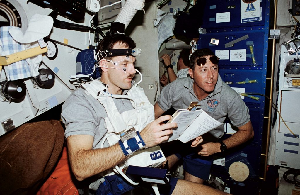 Steven L. Smith, left, conducts a biomedical experiment as Michael A. Baker monitors