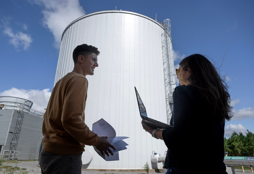 NASA Marshall Space Flight Center facilities engineers Connor McLean, left, and Angela Bell assess the readiness of Marshall’s new thermal energy storage tank, which officially goes into operation in October. The tank stands alongside Marshall’s original thermal tank outside Building 4473, where they chill and store water to cool off laboratories, offices, and other buildings during the hot summer months. McLean and Bell lead the tank project on behalf of Marshall’s Office of Center Operations.