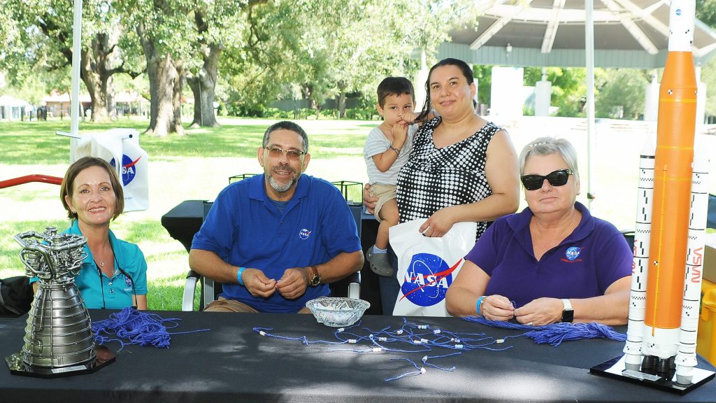 Event goers smile for a photo at the bracelet-making station