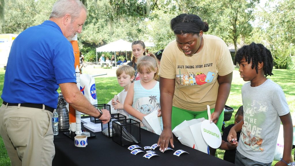 NASA representative Lacy Thompson passes out giveaways to event-goers