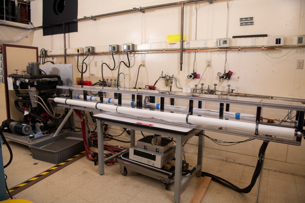 A rectangular rig surrounded by various wires, cables, and machinery.