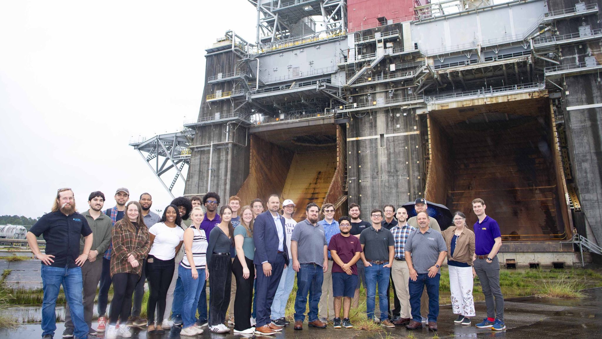 Members of the Society for the Advancement of Material and Process Engineering at Louisiana State University stand at the Thad Cochran Test Stand during a visit to NASA Stennis