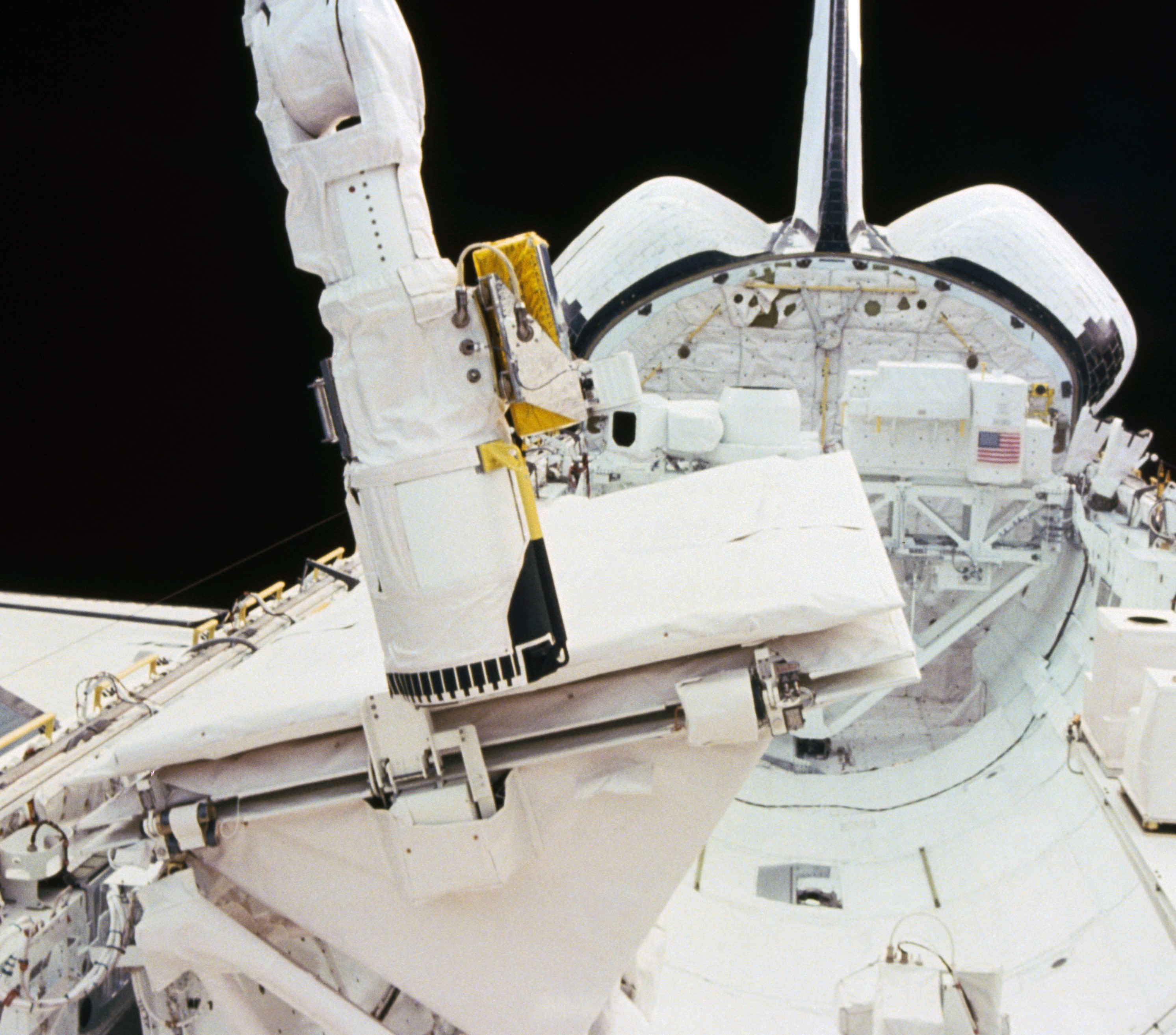 The shuttle's Canadian-built Remote Manipulator System or robotic arm closes the SIR-B panel