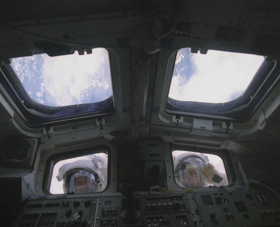 Sullivan, left, and Leestma peer into Challenger's flight deck during the spacewalk